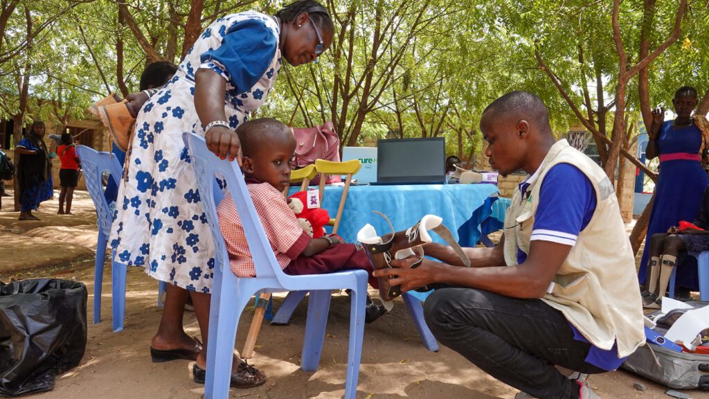 Dr Theuri fits Given with special footwear before his visit to CURE Kenya’s hospital (credit: P. Alderblad)