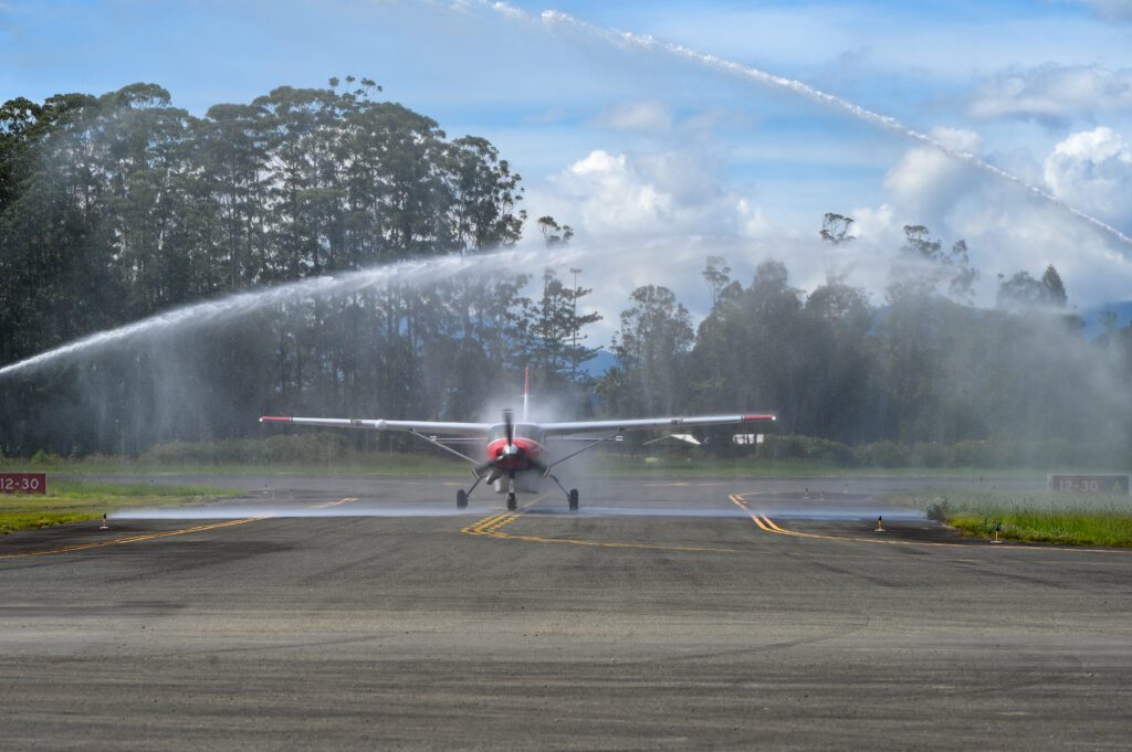 P2-AFD is welcomed to PNG by MAF’s ceremonial water salute (credit: WD Kretschmer)
