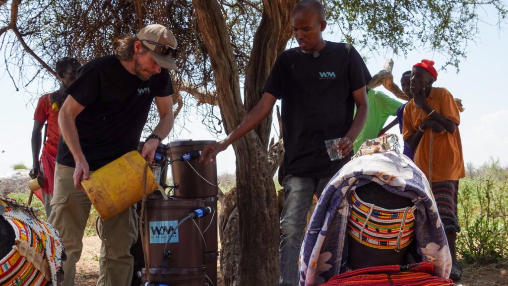 Marcus (L) & Meshack (R) demonstrate how the water filters work to communities (credit:Paula Alderblad)