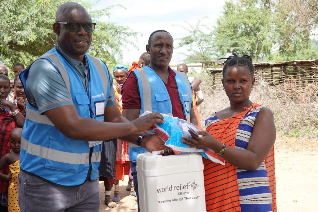 World Relief’s Oliver Otsimi (far left) distributes aid to the afflicted in Pakase (credit: Jacqueline Mwende)