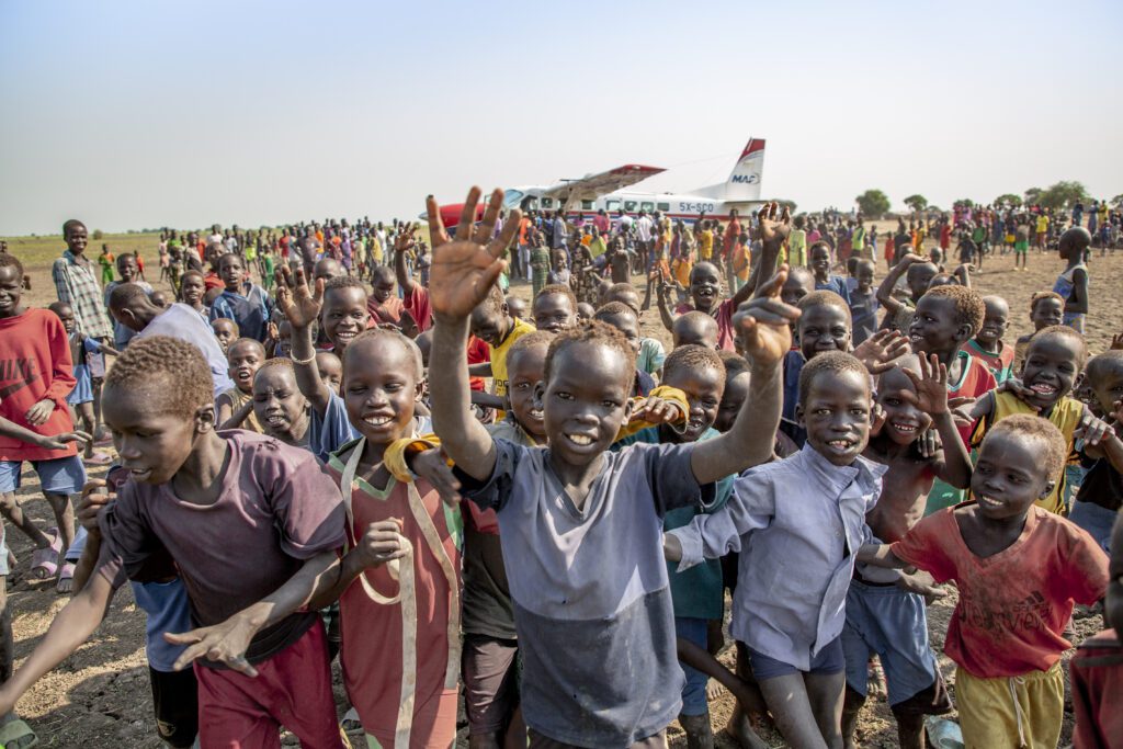 Excited crowds meet a MAF plane in Torput (credit: Dave F)