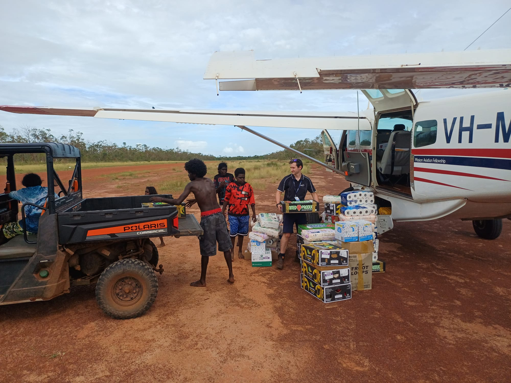 On landing, locals rush out to help unload supplies from MAF aircraft (credit: R.Griffiths /E.McMaster)